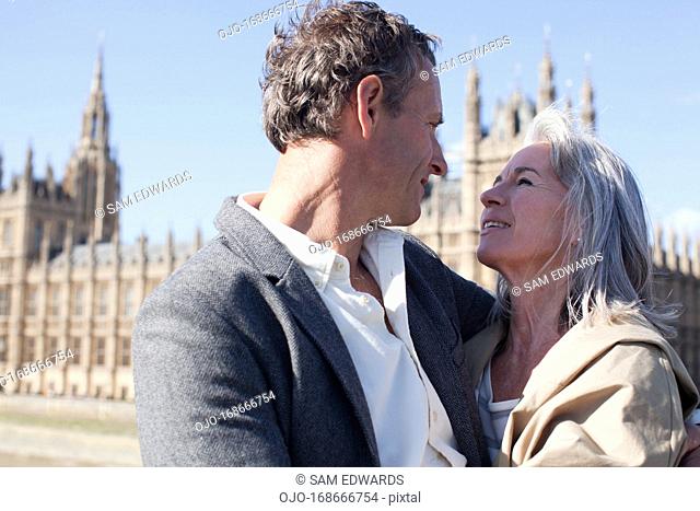Happy couple hugging in front of Parliament Buildings in London