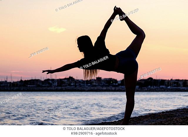 Young woman doing yoga, playa de Sa Rapita, Campos, Mallorca, balearic islands, Spain