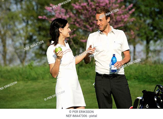 A Scandinavian man and woman taking a break at a golf course, Italy