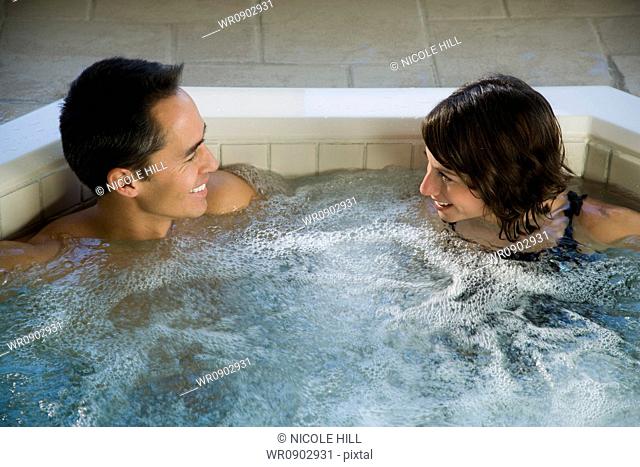 Man and woman in hot tub smiling