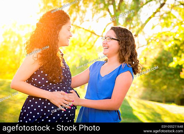 Hispanic Pregnant Mother With Young Daughter Outdoors
