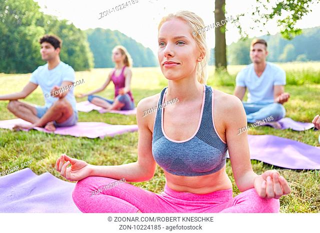 Frau im Yoga Workshop macht eine Übung zur Meditation in der Natur
