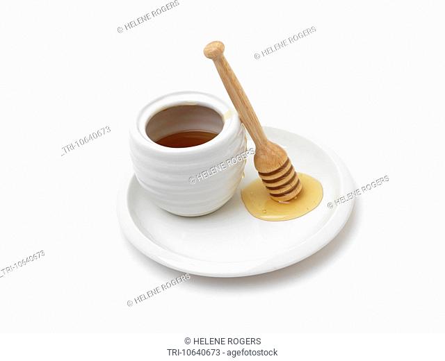 Honey In Honey Pot On A Plate And Wooden Honey Dipper