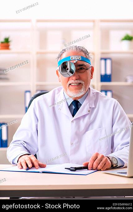 Aged male doctor laryngologist working in the clinic