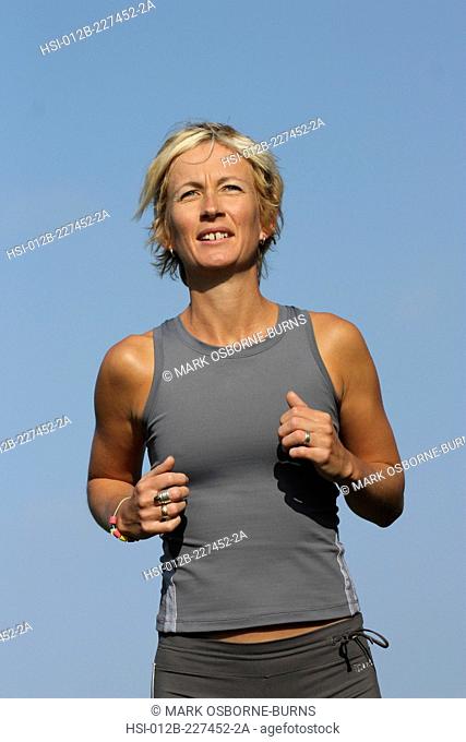 Blonde woman outdoors. Close-up. Jogging in countryside