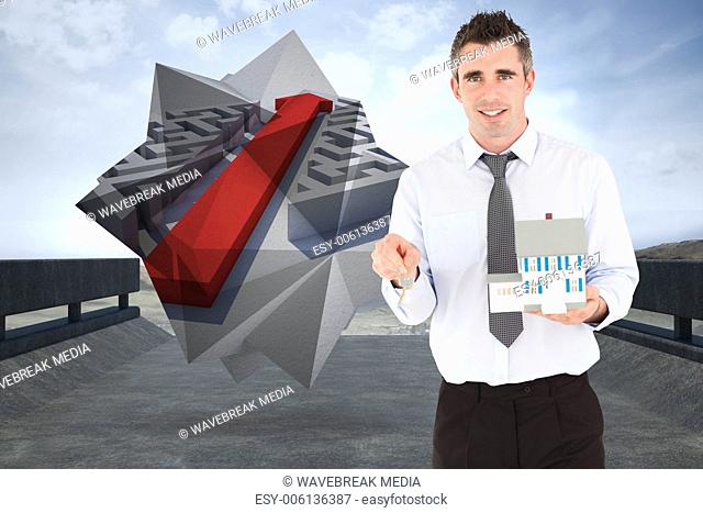 Composite image of businessman holding a key and a miniature house