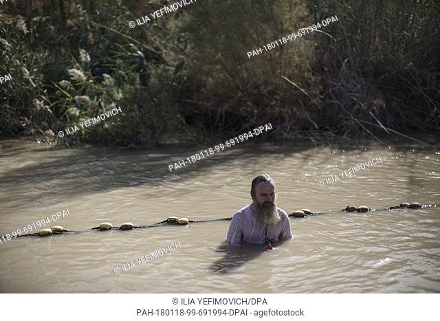 An Orthodox Christian pilgrim immerses himself in the waters of the Jordan River during the feast of the Epiphany at the West Bank baptismal site of Qasr el...