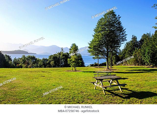 Picknick table on a lawn above lake Ta Anau, Manapouri, South Island, New Zealand