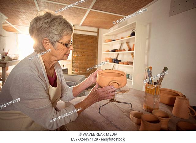 Female potter checking bowl
