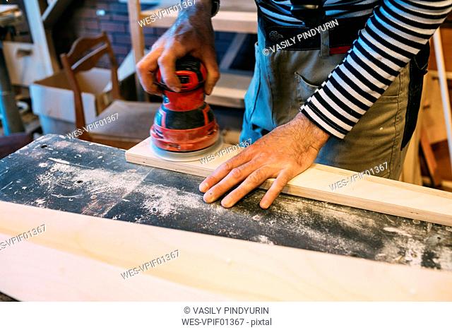 Carpenter at work, grinding wood