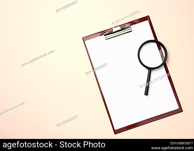 folder with blank white sheets and a black magnifier on a beige background. Background for inscriptions, search for solutions and answers