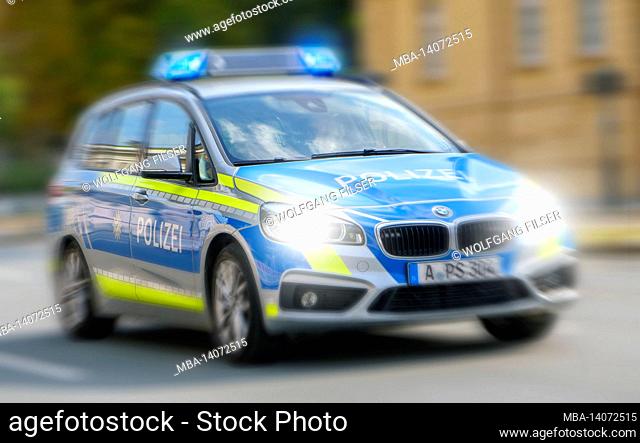 a police car drives through the city of augsburg at high speed and with blue lights