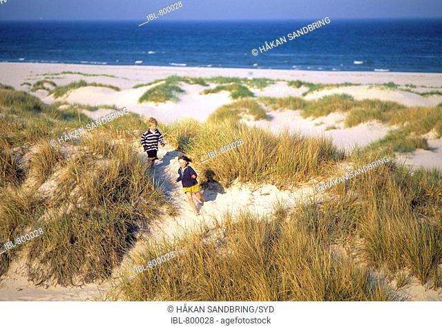 Boy and girl are playing on sand dunes