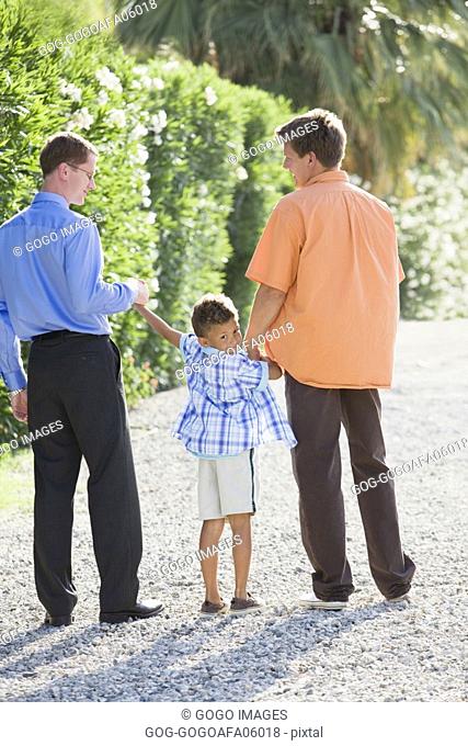 Gay couple walking with their son