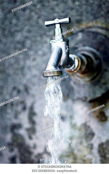 Close up of water running from outdoor wall faucet