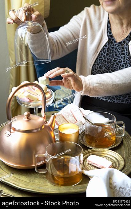 A stylish teatime with a copper pot, tea glasses and cake