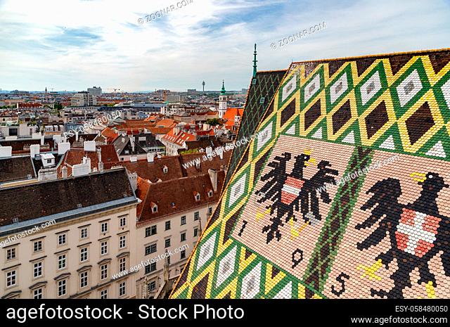 A panorama picture of the St. Stephen's Cathedral's rooftop art and the rooftops of the city