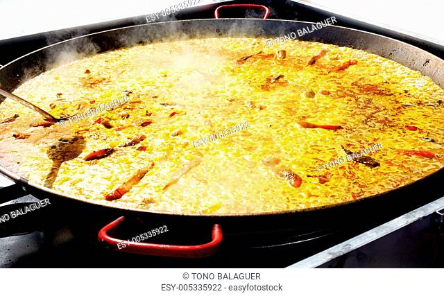 Paella rice from Valencia Spain cooking in big pan