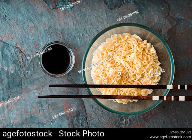 Soup Ramen noodles in glass bowl on tte blue background horizontal