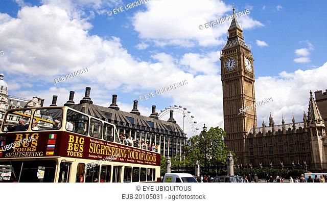 Westminster sight seeing bus with tourists passing by the Houses of Parliament Clock Tower better known as Big Ben