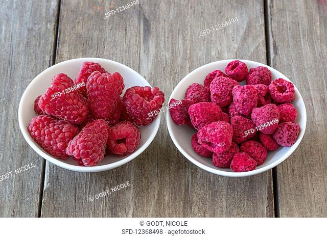 Fresh and freeze-dried raspberries in small bowls