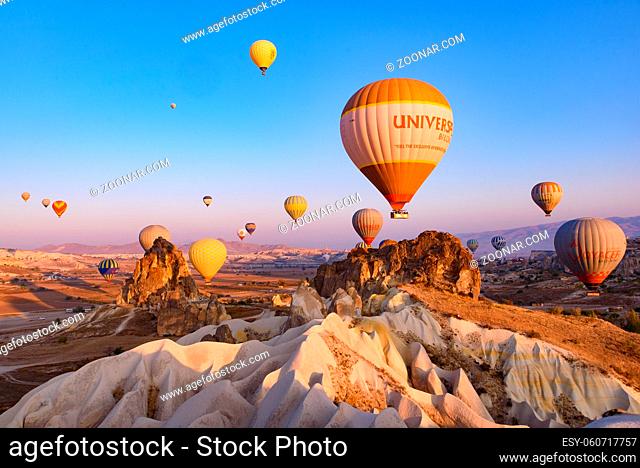 Flying hot air balloons and rock landscape at sunrise time in Goreme, Cappadocia, Turkey