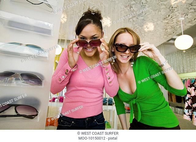 Two Girls Trying on Sunglasses in Boutique portrait