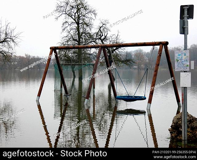 01 February 2021, Baden-Wuerttemberg, Bechingen-Zell: A playground is under water on the banks of the Danube. Melting snow and rainfall have led to rising water...