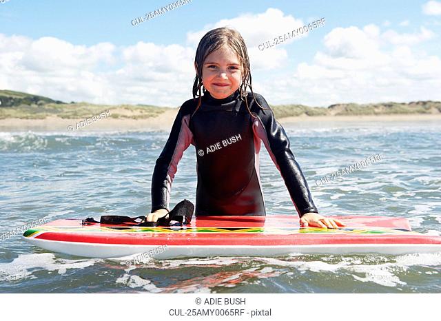 Young girl in the sea with surf board