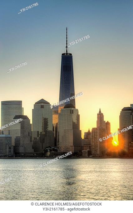 The sun rises over lower Manhattan as the Freedom Tower 1 World Trade Center stands tall nearby in the World Trade Center complex, in New York City, New York