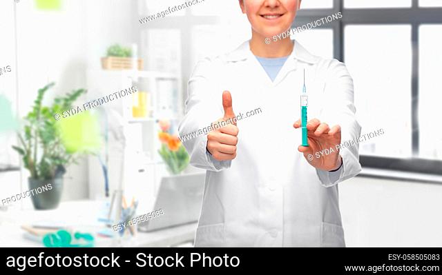 doctor with syringe showing thumbs up at hospital
