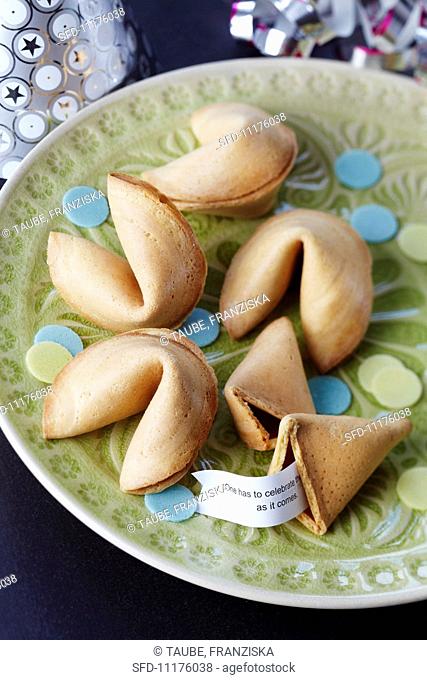 Fortune cookies with rice paper confetti on a plate