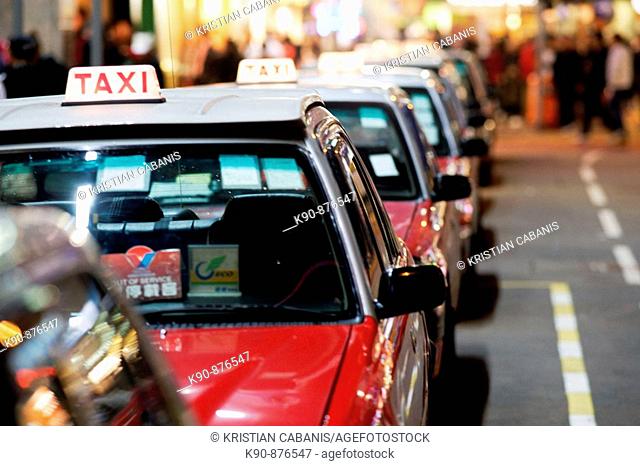 The typical red taxis queueing up idle at a taxi stand in Wanchai (Wan Chai) and waiting for customer, Hong Kong Island, Hong Kong, China, East Asia