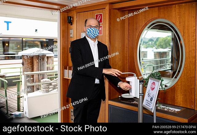 28 May 2020, Bavaria, Starnberg: Albert Füracker (CSU), Minister of Finance and Home Affairs of Bavaria, disinfects his hands on the MS Starnberg