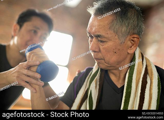 Senior man undergoing rehabilitation with trainer