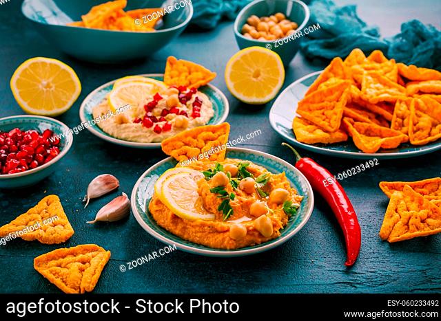 Homemade spicy humus with pomegranate seeds, chilli and chickpeas tortilla chips