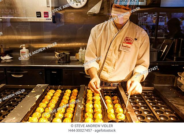 Japan, Hoshu, Tokyo, Chef Making Takoyaki (Batter and Octopus Balls)