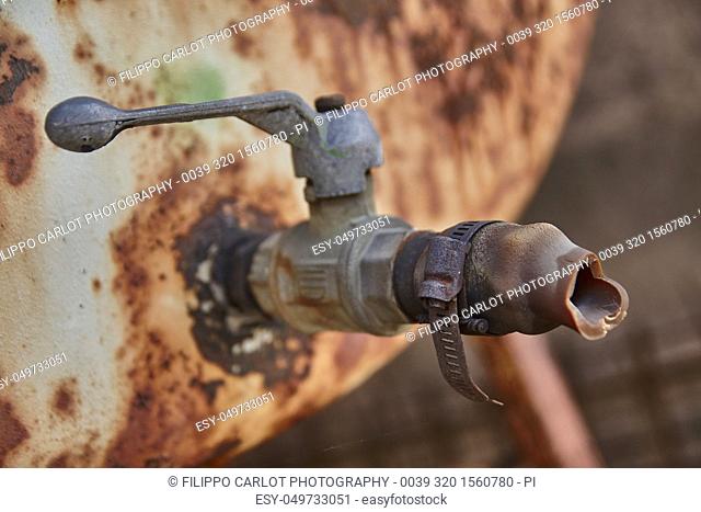 Detail of an old rusty faucet corroded by weather and weather