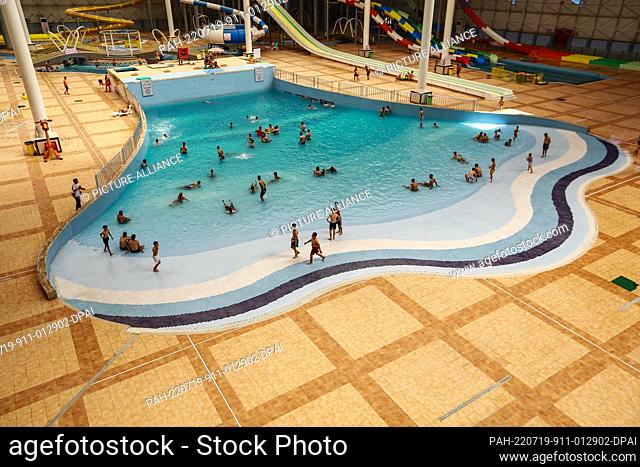 19 July 2022, Iraq, Baghdad: People swim at an Aqua Park amid an ongoing heatwave in Iraq. Iraq experiences a heatwave with temperatures soaring to over 45...