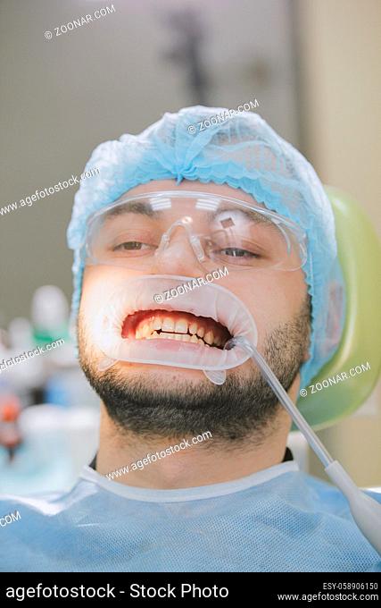 Stomatology - male patient at dentist's chair, close up