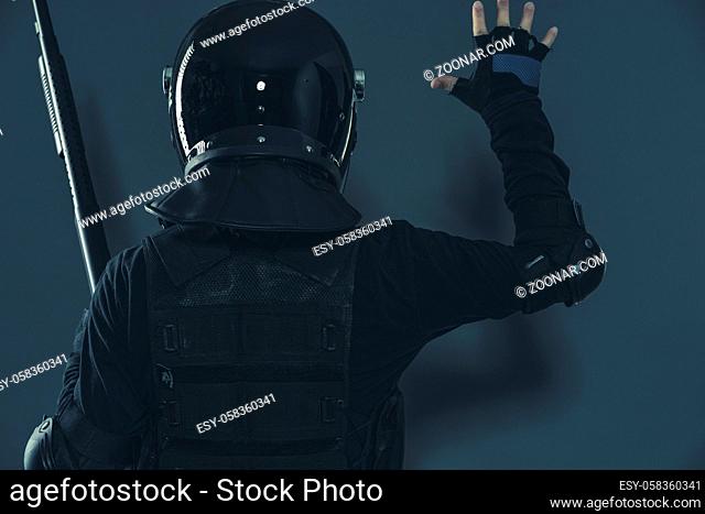 riot police signaling to colleagues with their hands. armed man with helmet and bulletproof vest