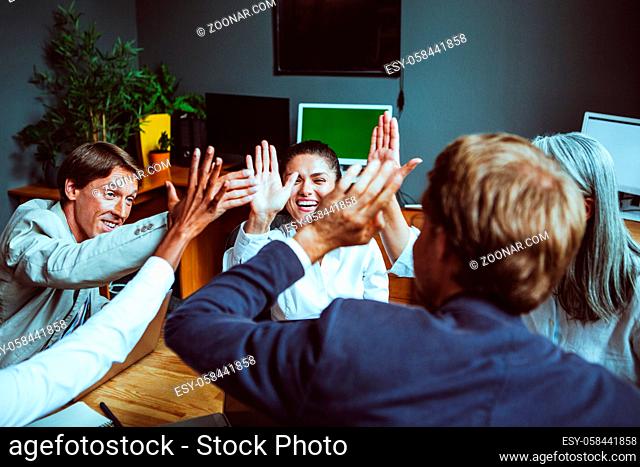 Business people giving each other high five and clapping. Business team celebrating success. High quality photo