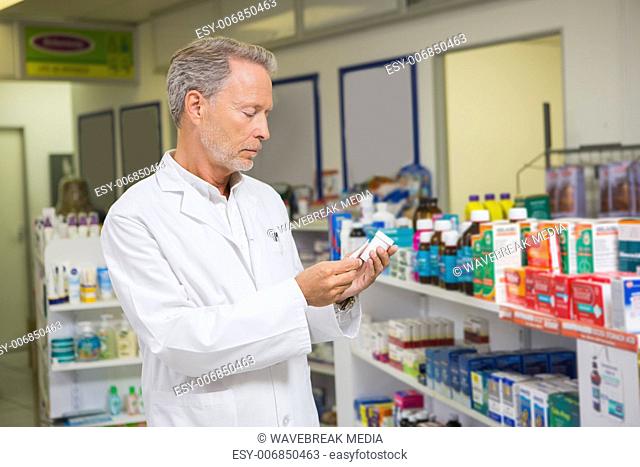 Senior pharmacist looking at medicine