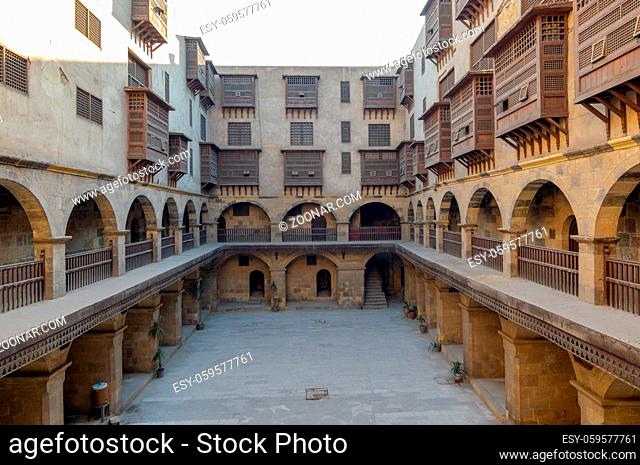 Facade of caravansary (Wikala) of Bazaraa, with vaulted arcades and windows covered by interleaved wooden grids (mashrabiyya), suited in Tombakshia street