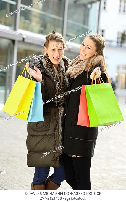 Two young woman with their bags from a shopping tour in a city in Germany