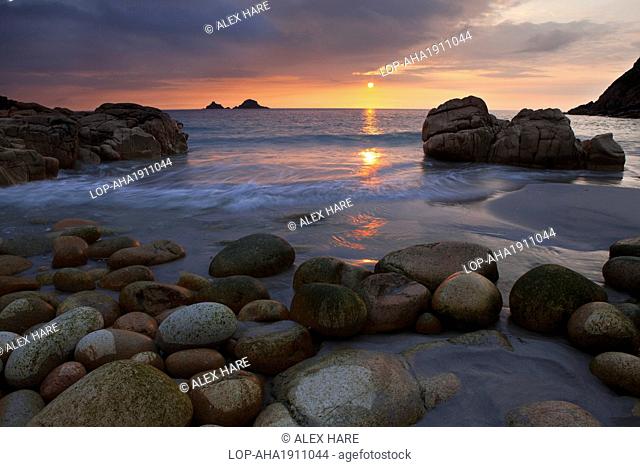 England, Cornwall, Porth Nanven. Sunset over the sea viewed from Porth Nanven, a beach sometimes referred to as 'Dinosaur Egg Beach' because of large deposit of...