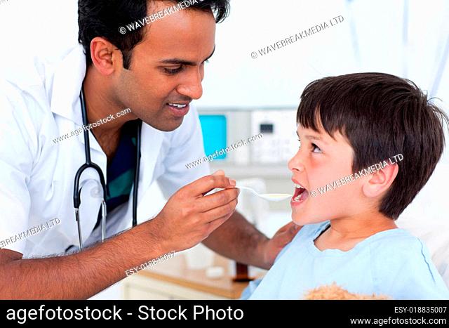 Young doctor giving medicine to a little boy