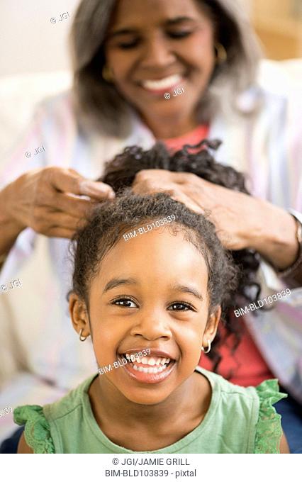 African American woman fixing granddaughter's hair
