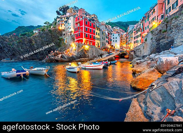 Riomaggiore fishing village during evening twilight blue hour, seascape in Five lands, Cinque Terre National Park, Liguria, Italy
