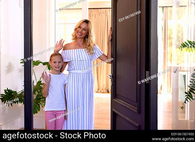 Caucasian woman and her daughter welcoming a visitor